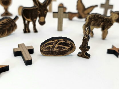 Christliche Dekoration - Brot, Kerze, Kreuze und im Hintergrund Esel, Taube