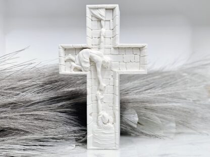 Ein handgefertigtes Hoffnungskreuz aus Jesmonite mit der Darstellung der helfenden Hand Jesu Christi.